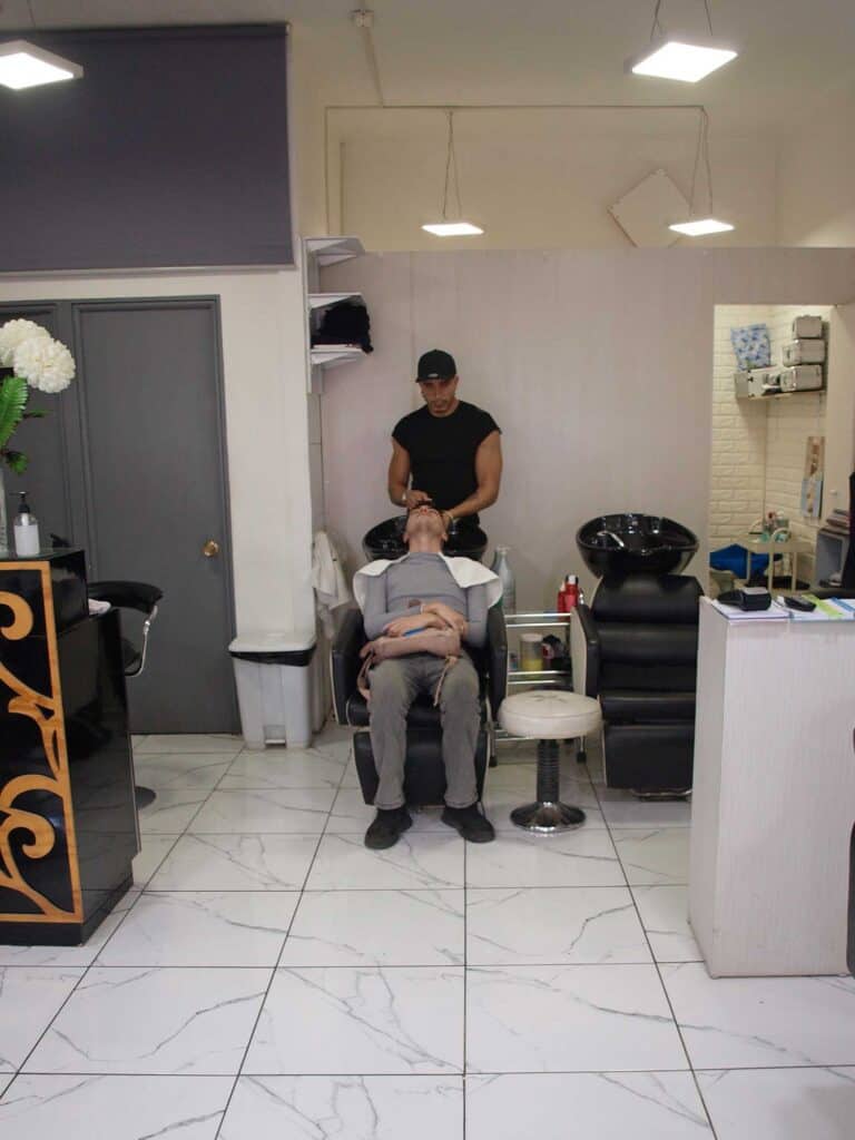 Hombre siendo atendido en barbería