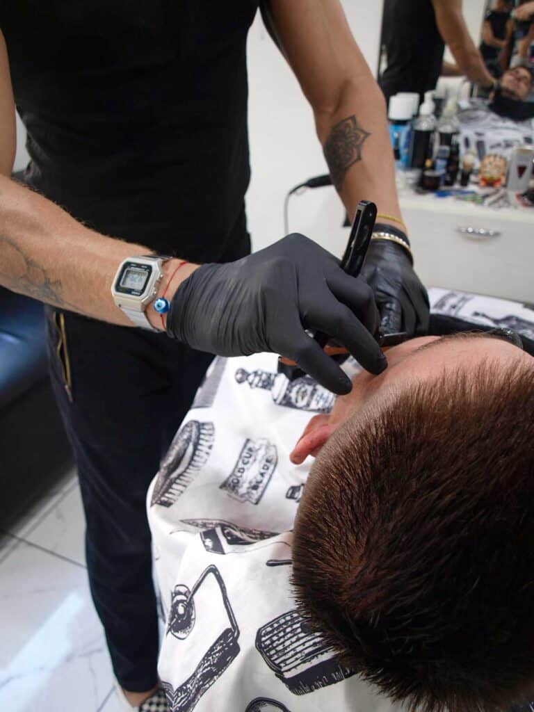 Hombre siendo atendido en barbería